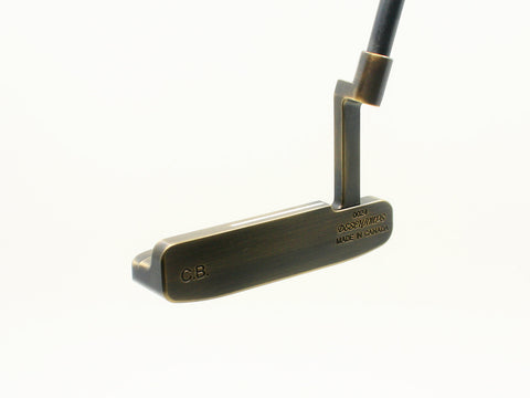 Golf putter with brass head and black shaft on a white background